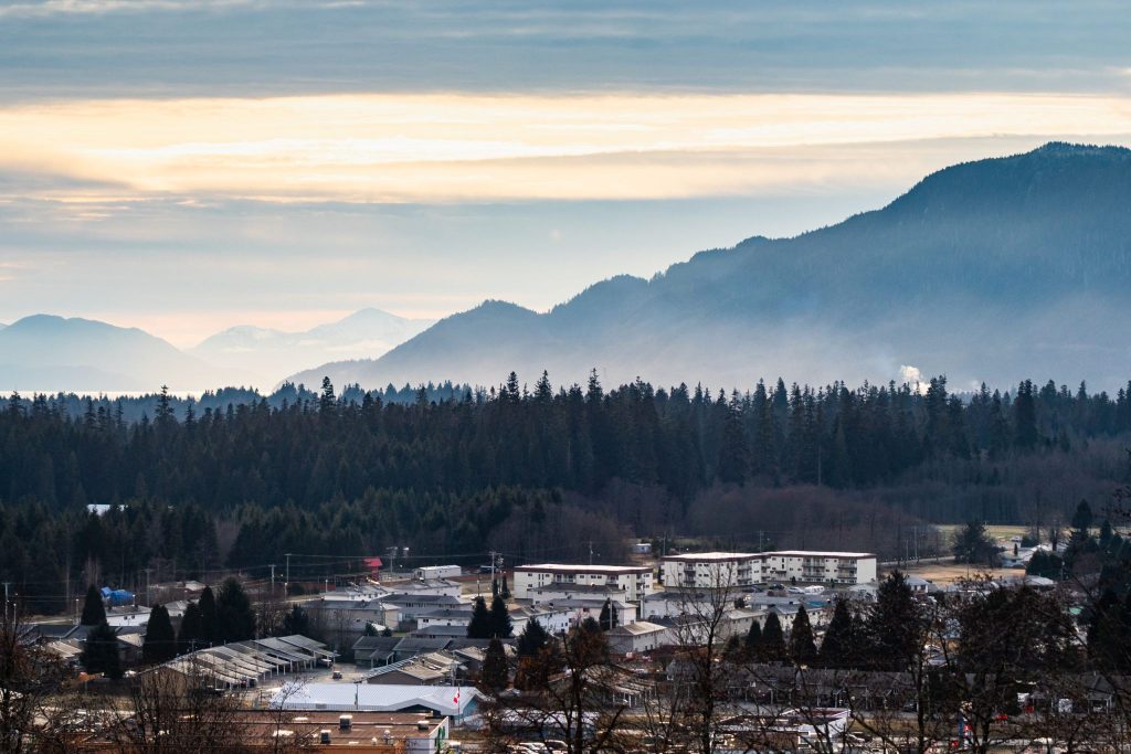 Kitimat at dusk, with forest and mountains rising behind the town
